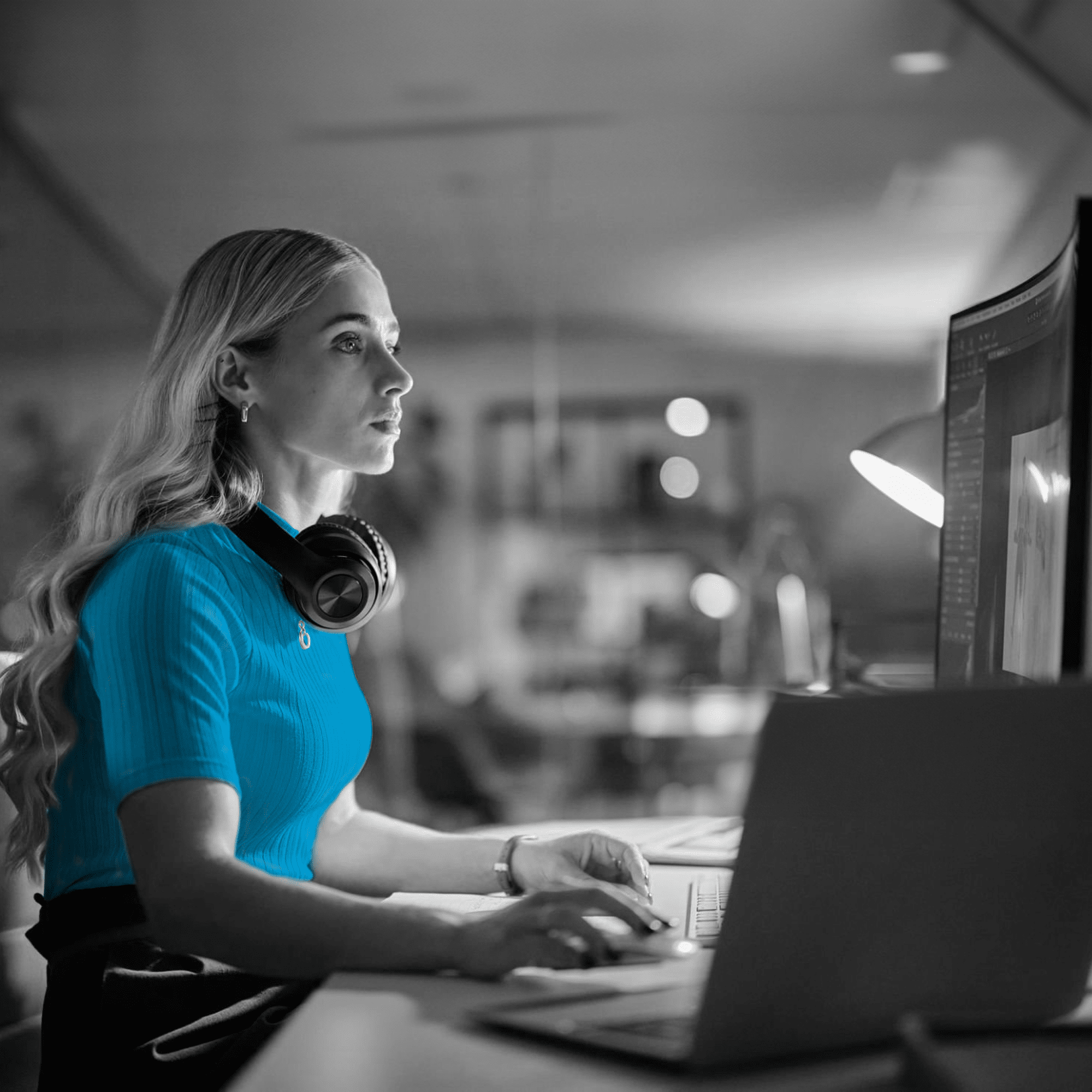a woman sitting at a desk with a laptop and headphones on